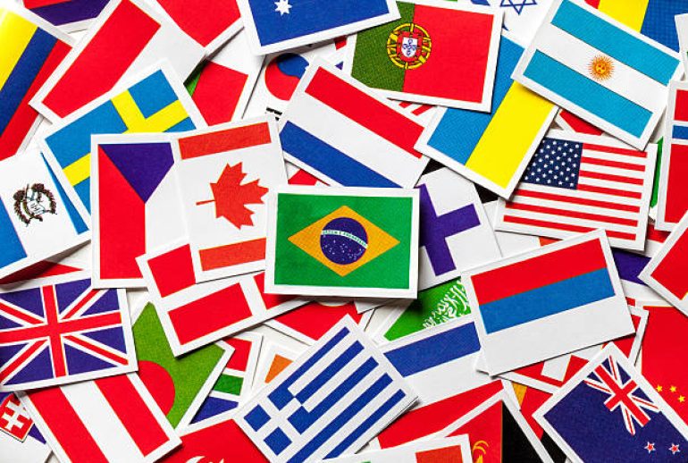 National flags of the different countries of the world in a scattered heap. Brazilian flag in the center.